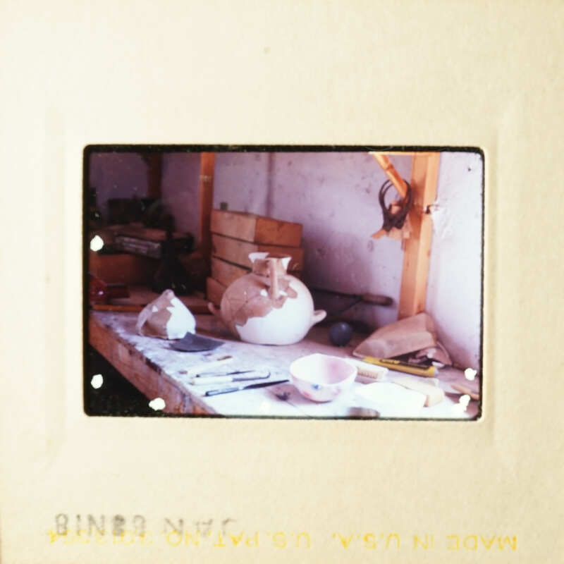 A cat sitting on a table in a workshop.