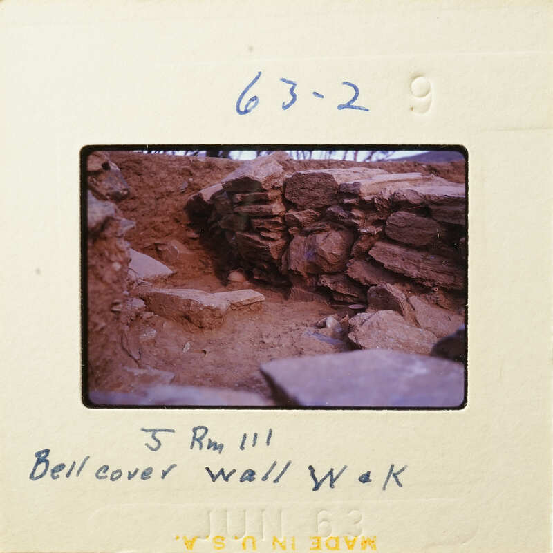 Stone ruins with dirt and vegetation, possibly part of an archaeological site.