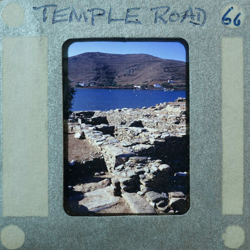 Various stone walls with water and mountains in the background.