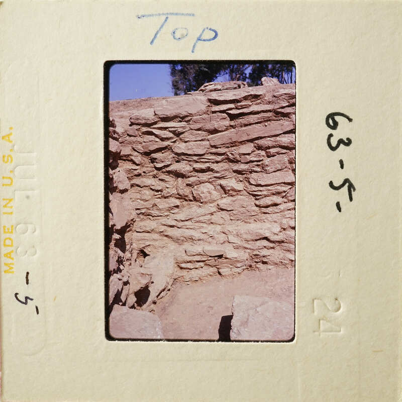 Old stone ruins with vegetation, captured on a vintage photographic film strip.