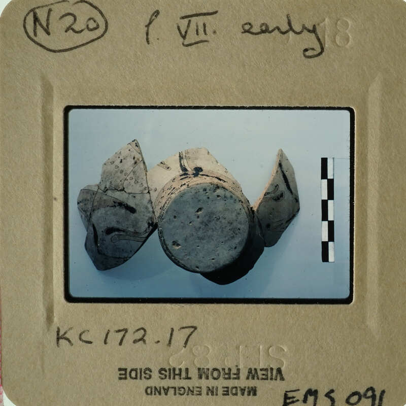 Old ceramic objects displayed on a white surface with visible age and wear.