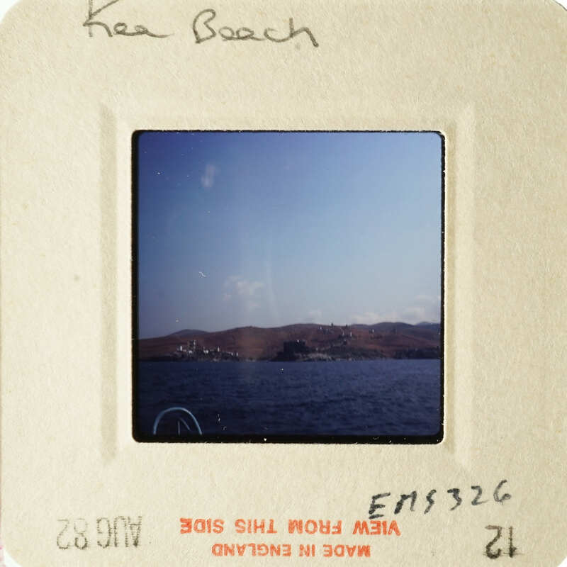 A photograph of a serene beach scene with calm waters and distant mountains.