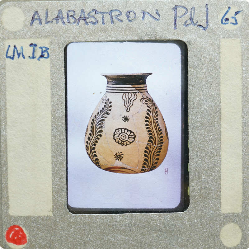 An image of an alibastron vase with an intricate design, placed on a white surface.