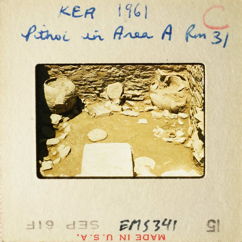 Archaeological site with stone ruins and scattered pottery shards.