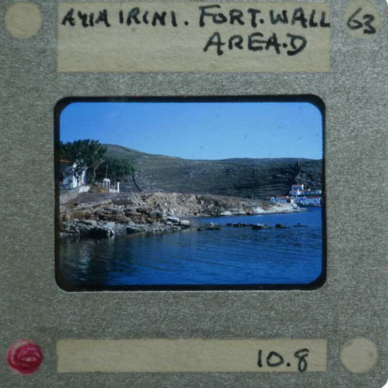 A vintage film strip with a picture of a coastal landscape, including water and hills.