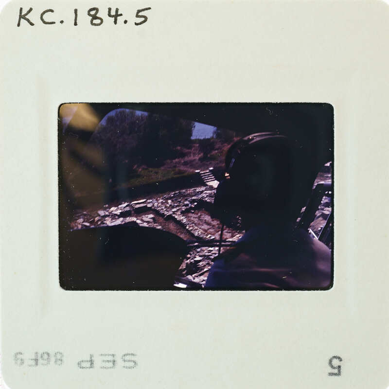 A person wearing a helmet and headset, possibly in a helicopter cockpit.