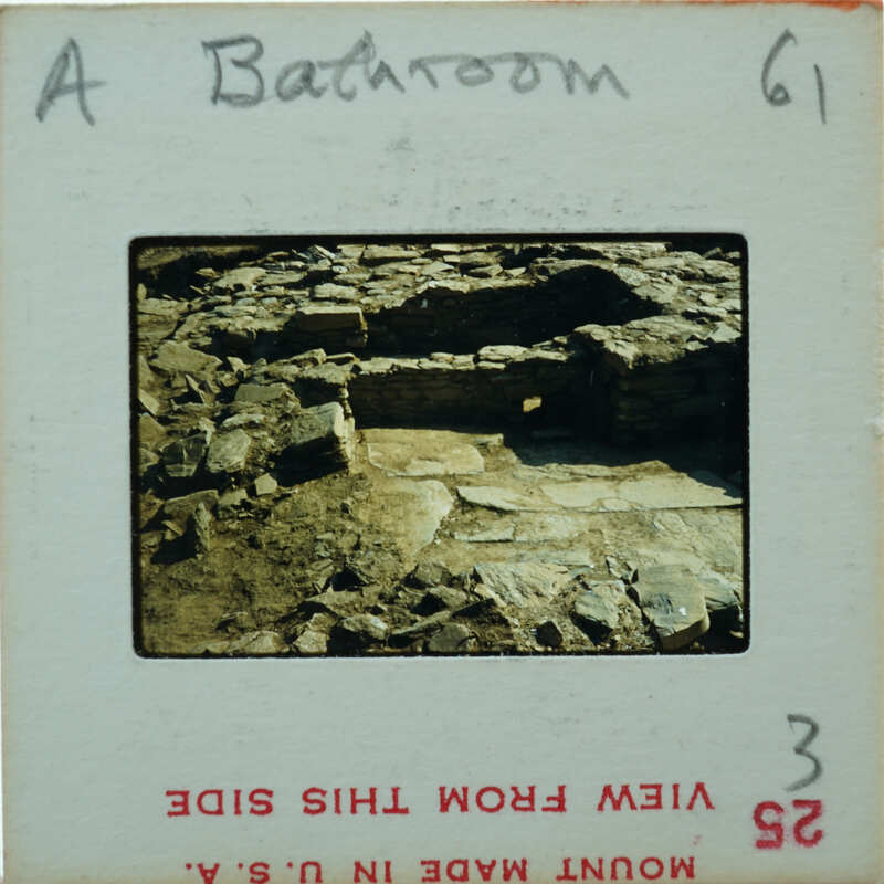 A photograph of an old stone structure, possibly ruins, with a vintage film strip border.