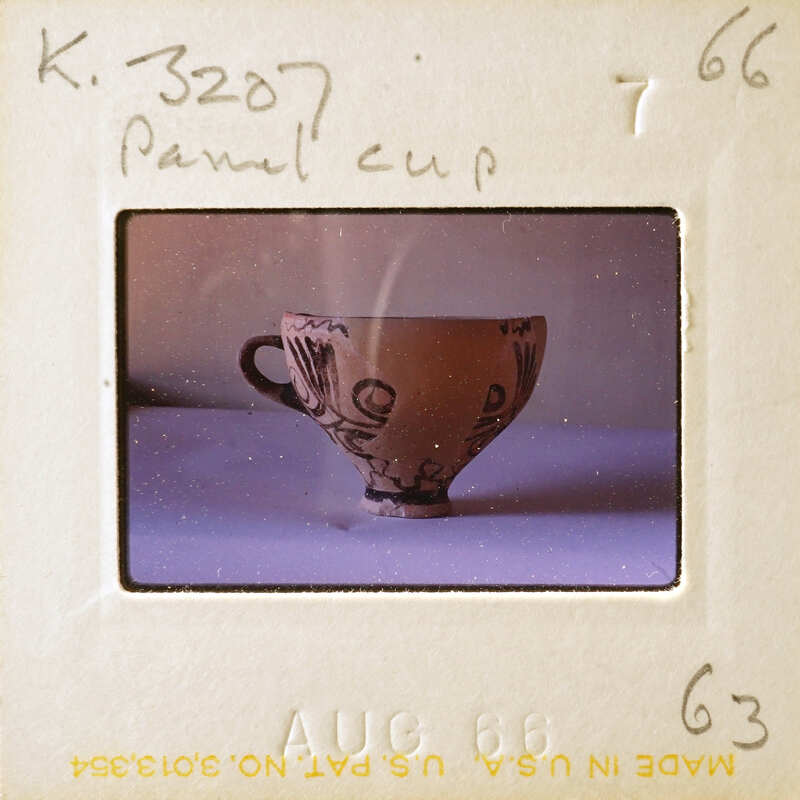 A sepia-toned photograph of a decorative cup on a table.