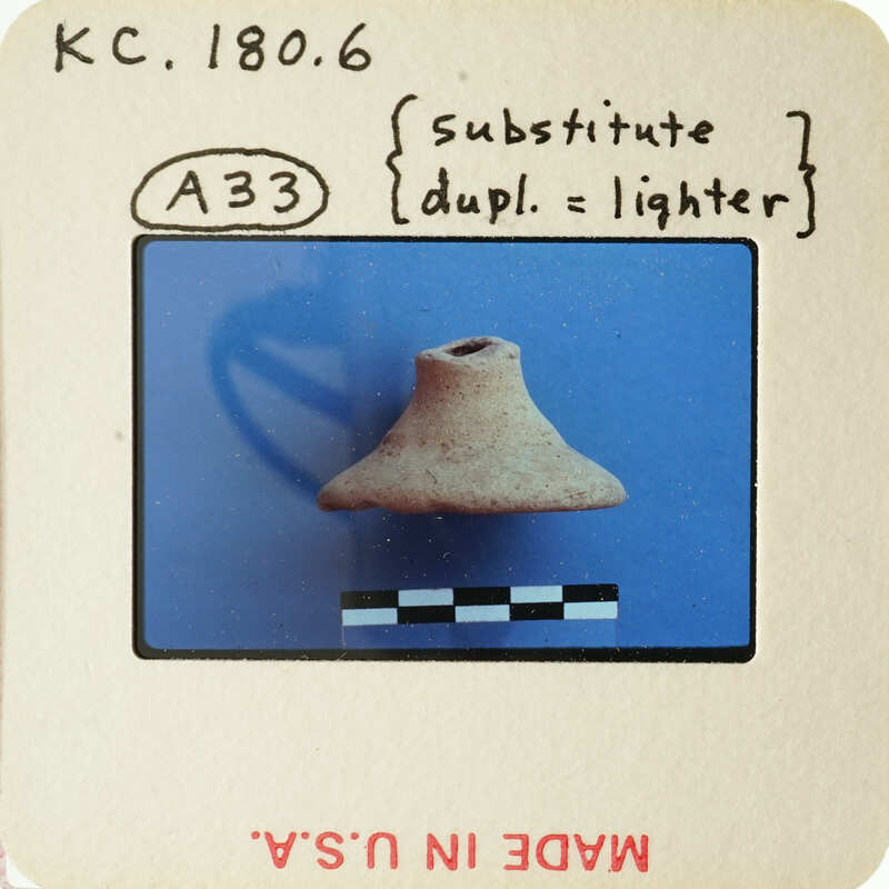 A photograph of an old slide featuring a clay pot on a blue background with measurement lines and annotations.