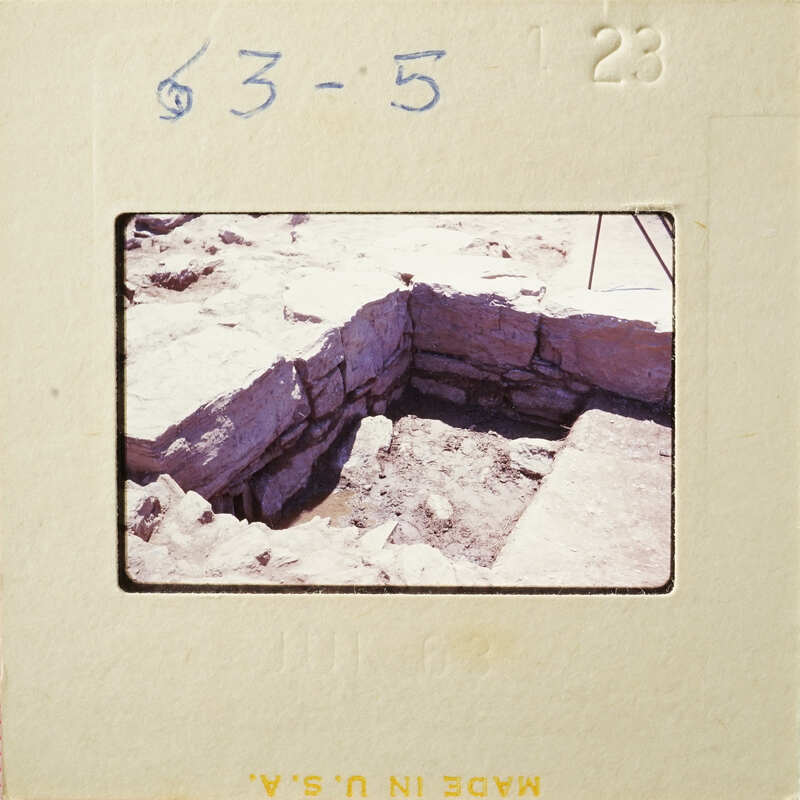 This is an image of a stone-lined pit with dirt at the bottom, possibly part of an archaeological site.