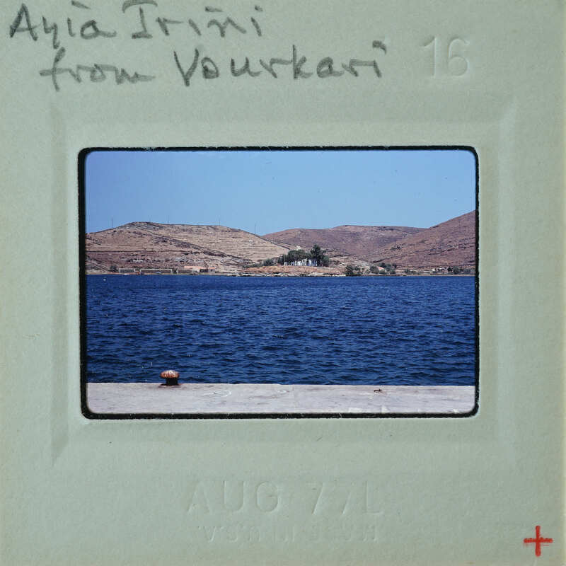 A vintage postcard featuring a scenic view of a body of water, possibly an ocean or sea, with mountains in the background and a pier extending into the water.