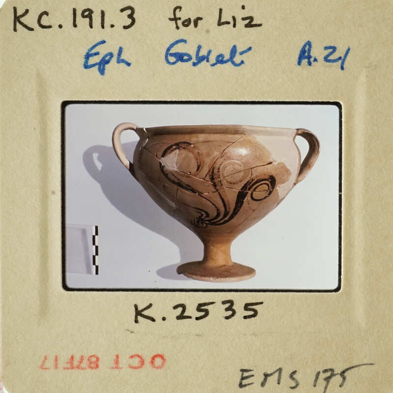 Ancient Greek vase with intricate designs and handles, displayed on a stand.