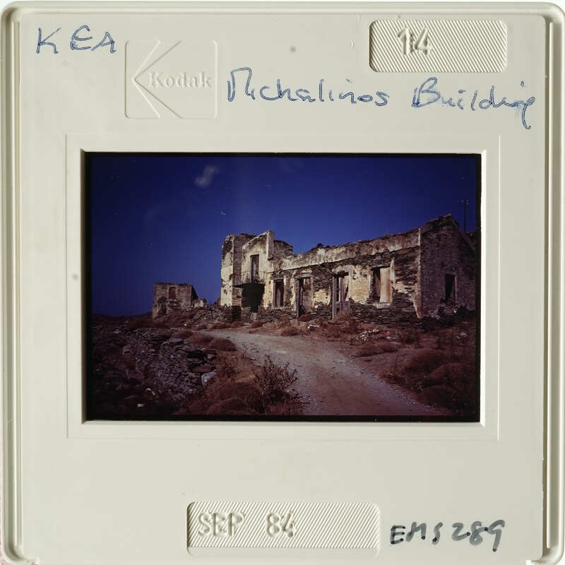 Old photograph of an abandoned building with a dirt road and sky background.