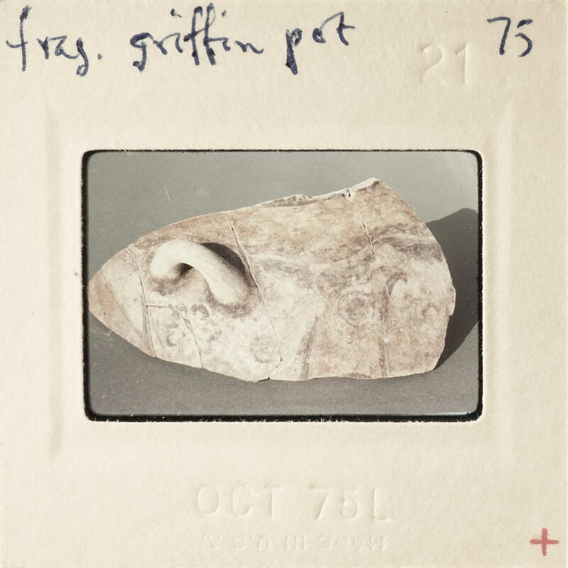 A photo of a small, ancient stone artifact with a human-like face on it.