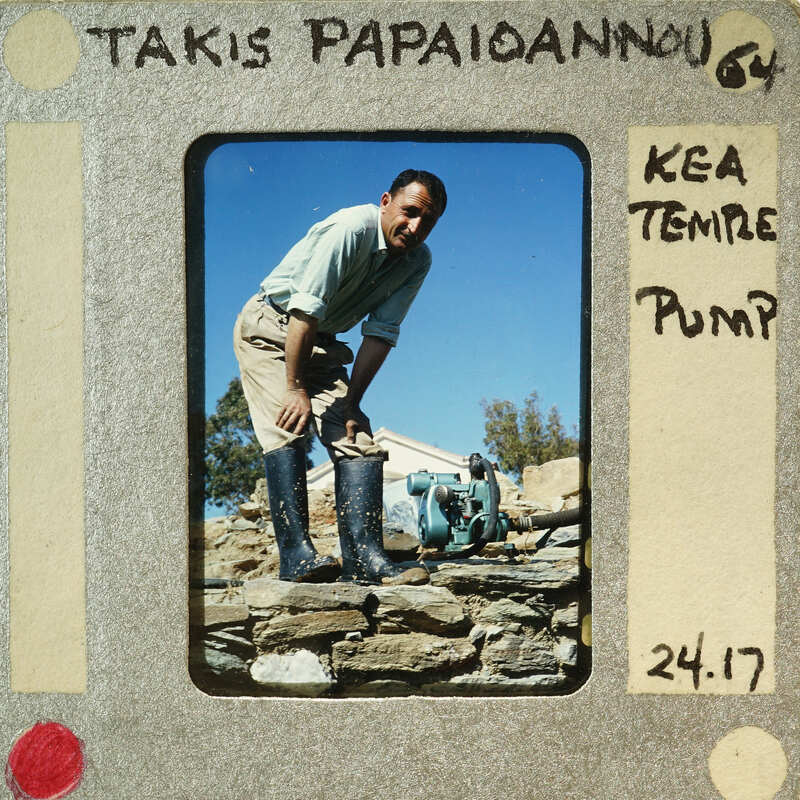 Man wearing boots working on a stone wall.