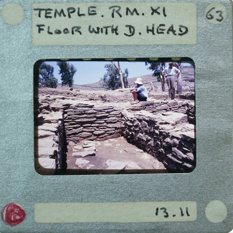 Stone walls with various surfaces and terracotta head on floor.