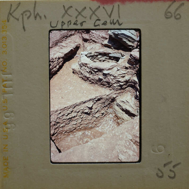 A photograph of a rocky archaeological site with ancient ruins and rock formations.