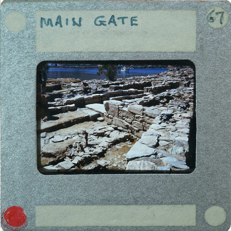 A vintage photo of ancient ruins, possibly a city gate, enclosed in an old-fashioned film strip holder with handwritten labels and numbers.
