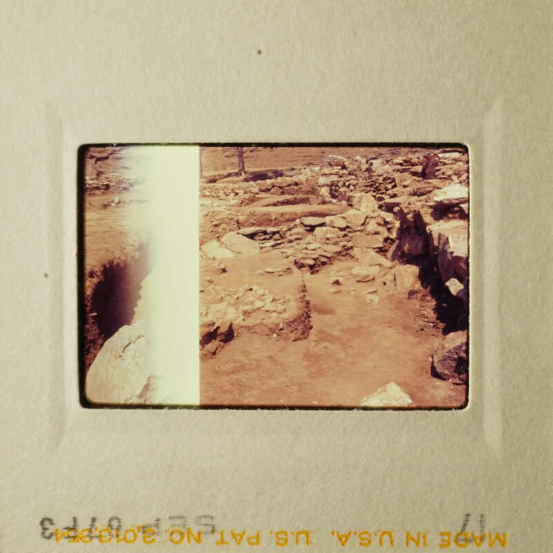 This is an old photograph depicting an archaeological site with ruins and rubble.