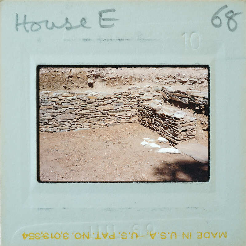 Excavated stone walls with doorway on the right.