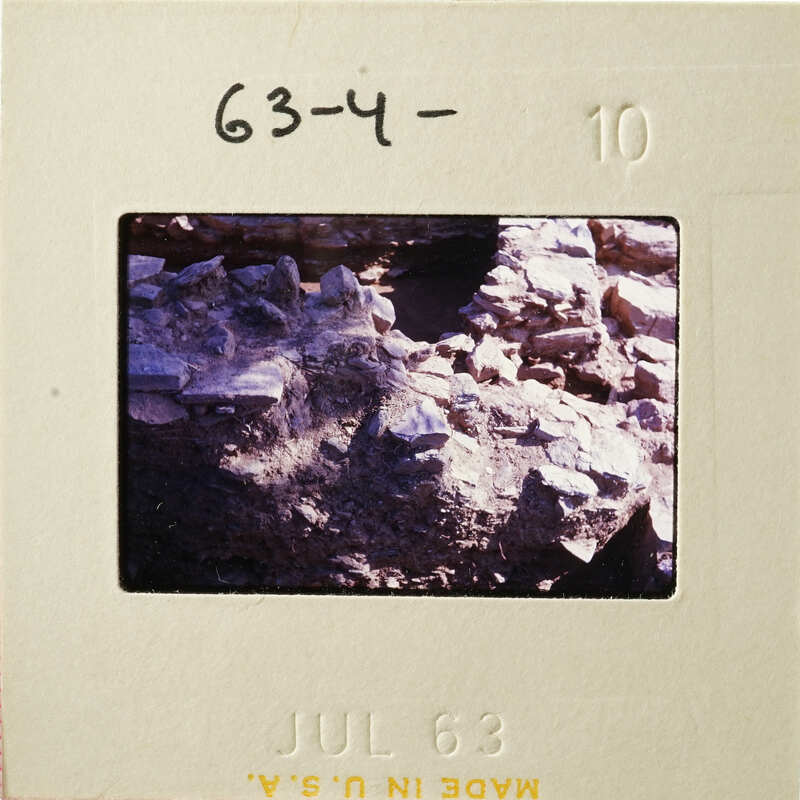 A photograph of an archaeological site with rocks and dirt, dated July 1963.