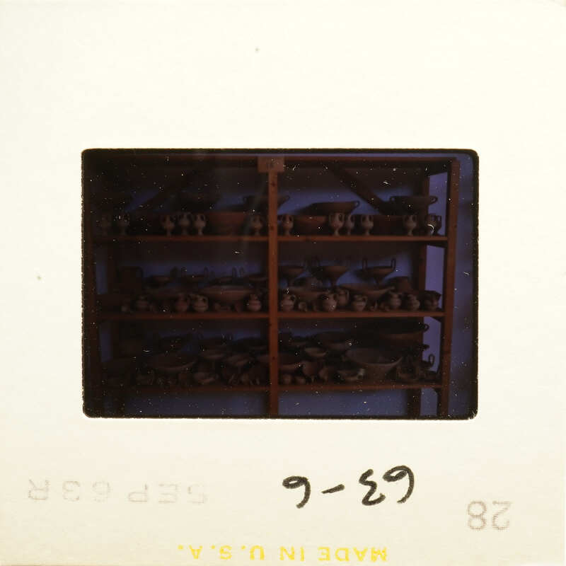 Old photograph showing shelves filled with various pottery items.