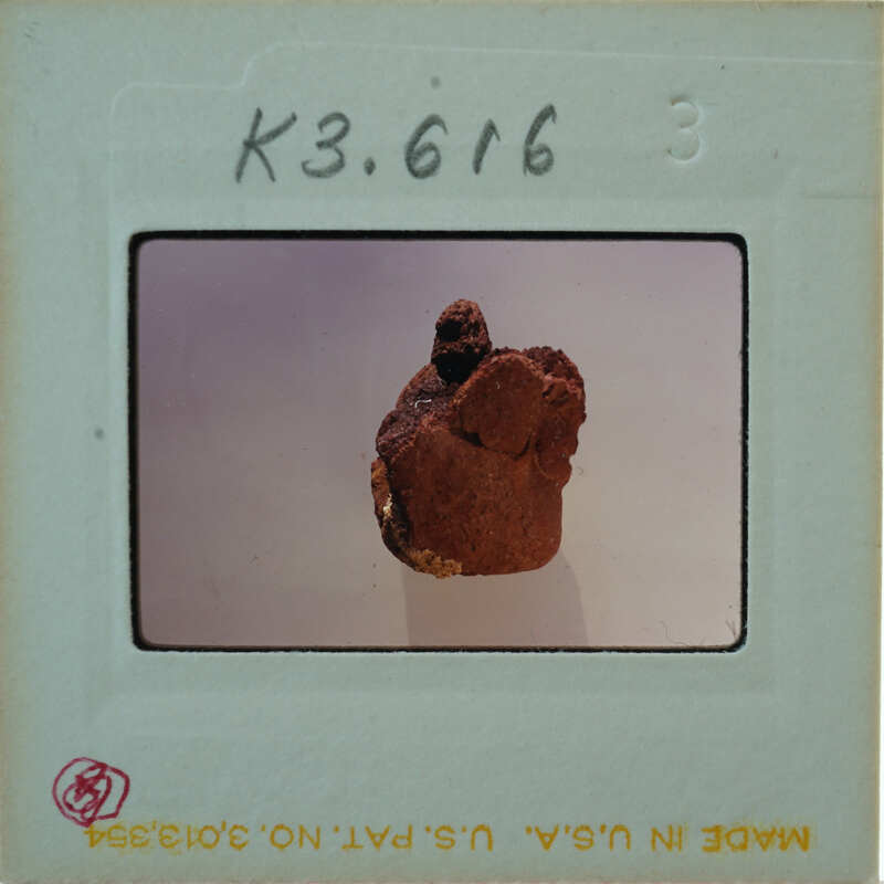 A photograph of a clay face mask on display.