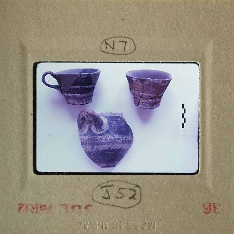 Broken ceramic pieces on display, including cups and bowls.