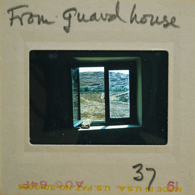 A photograph of a window with a view, displayed on a film strip.