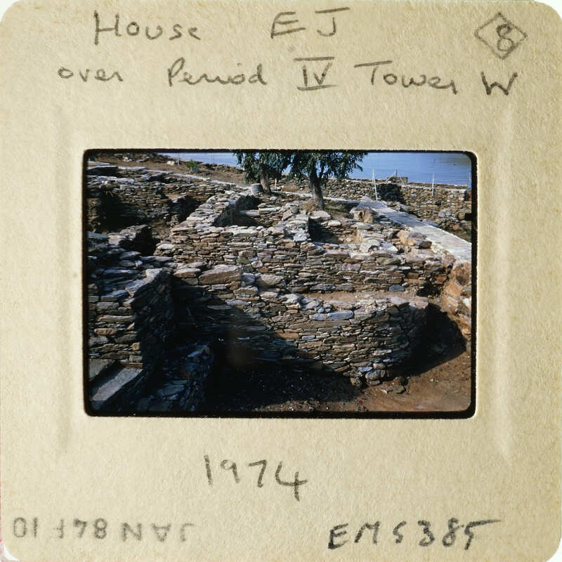 A photograph of an ancient stone structure, possibly ruins, with trees and sky in the background.