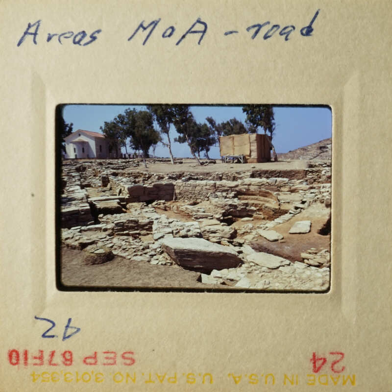 The photo shows an archaeological site with stone ruins, and there is a sign indicating "Areas Maa - Road."