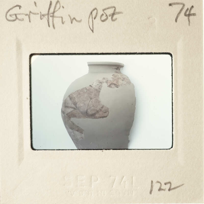 An image of a clay pot with markings on it, displayed against a white background.