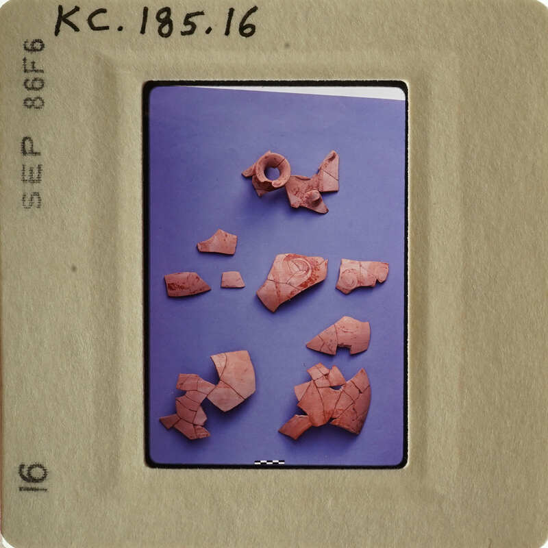 Pinkish clay pottery fragments on blue background.