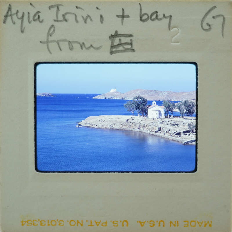 Picture of a scenic coastal landscape with blue water, land and buildings.