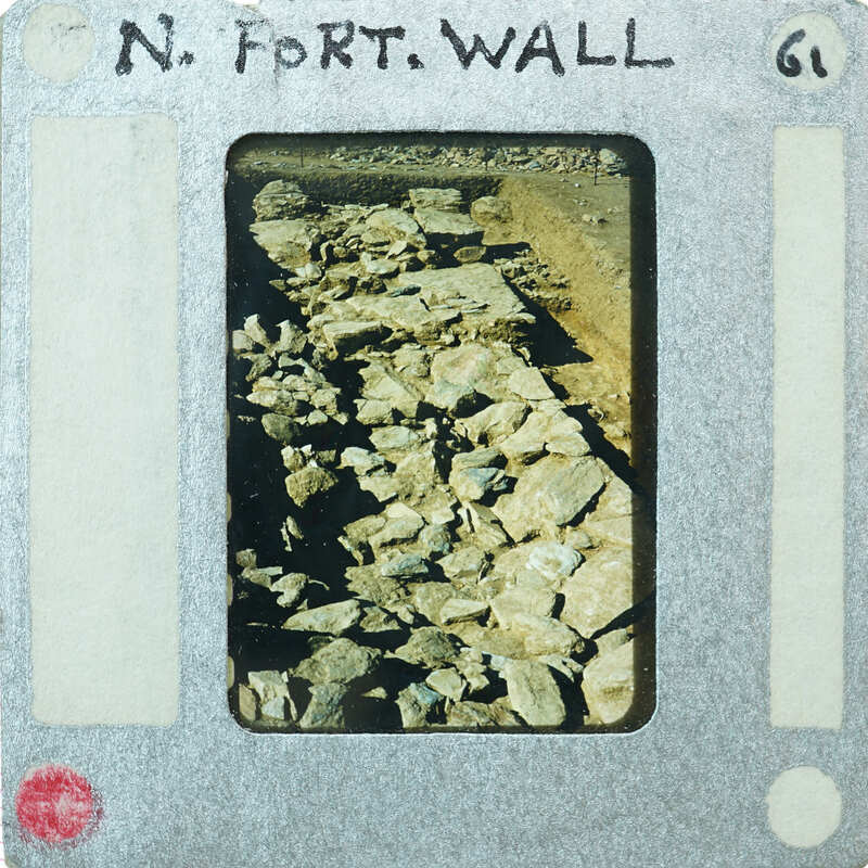 Old photograph of rock wall on film strip with label "N. Fort Wall".