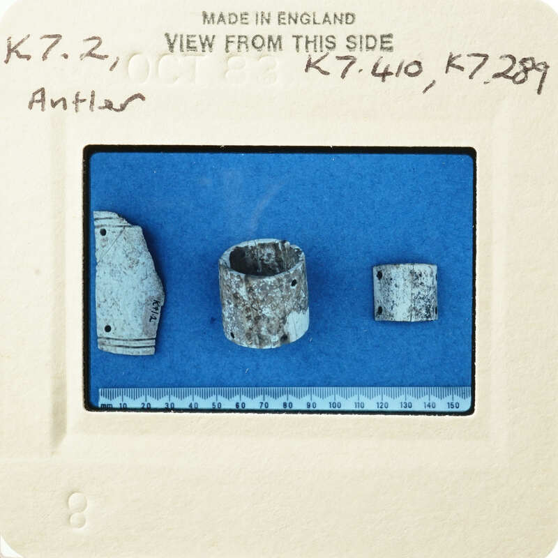 Old ceramic fragments on blue paper with measurements and labels.