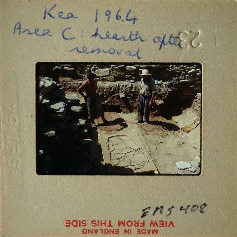 Two men working on an archaeological site with stone ruins and excavated areas.