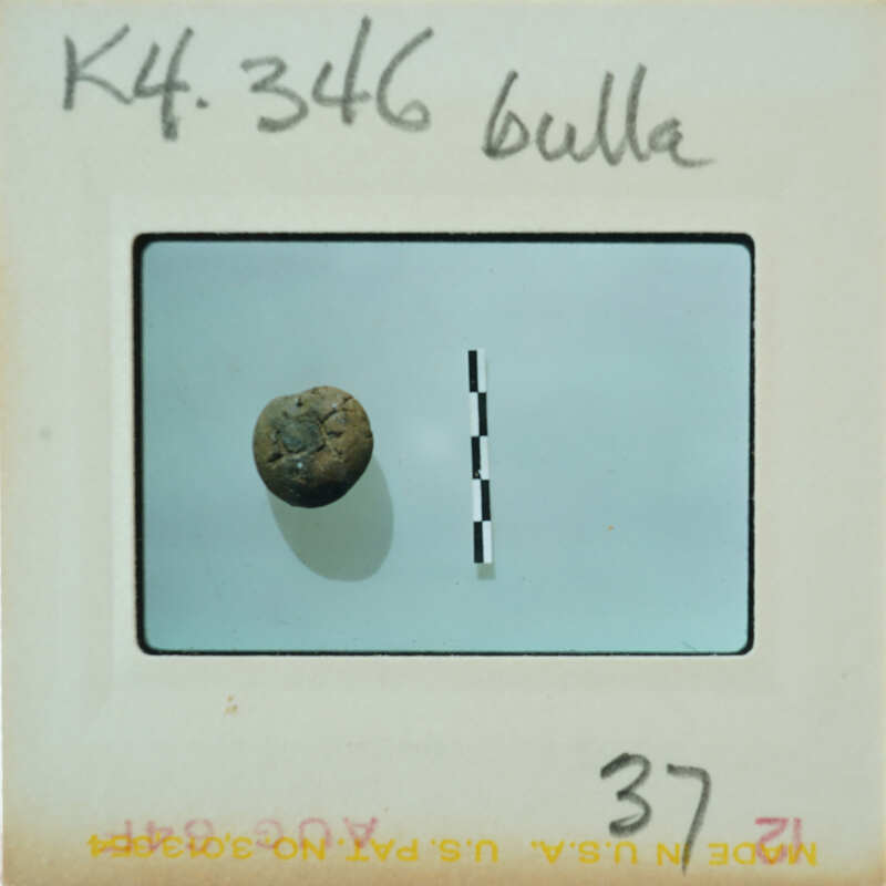 A small, round object with a rough surface on a white background with measurements and labels.