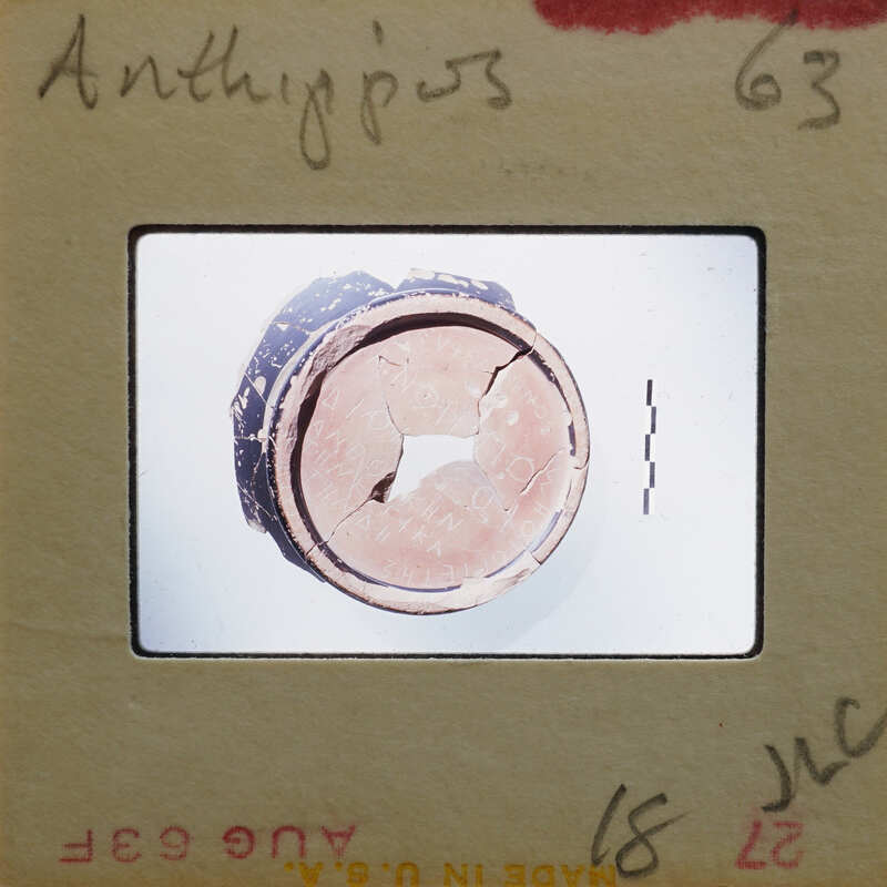 Old photograph of a cracked, circular object with a dark center and concentric rings.
