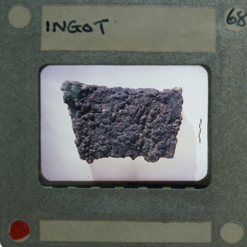 Close-up image of a rock with various textures and colors, captured through a magnifying glass or microscope.