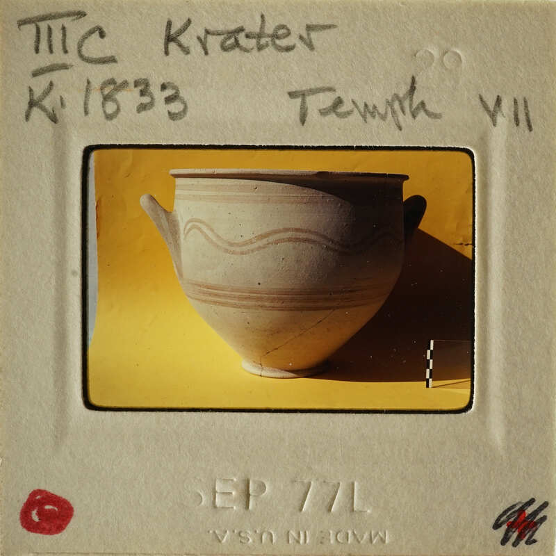 Ancient ceramic pot with markings on display.