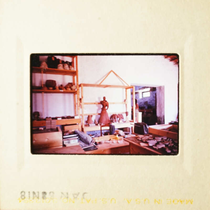 This is an old photograph of a pottery studio with various items and tools on display.