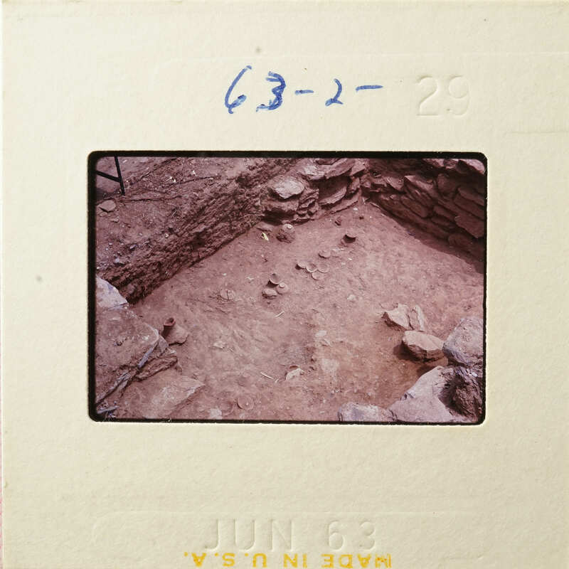 Ancient ruins with stone walls and rubble, captured on a vintage film strip.