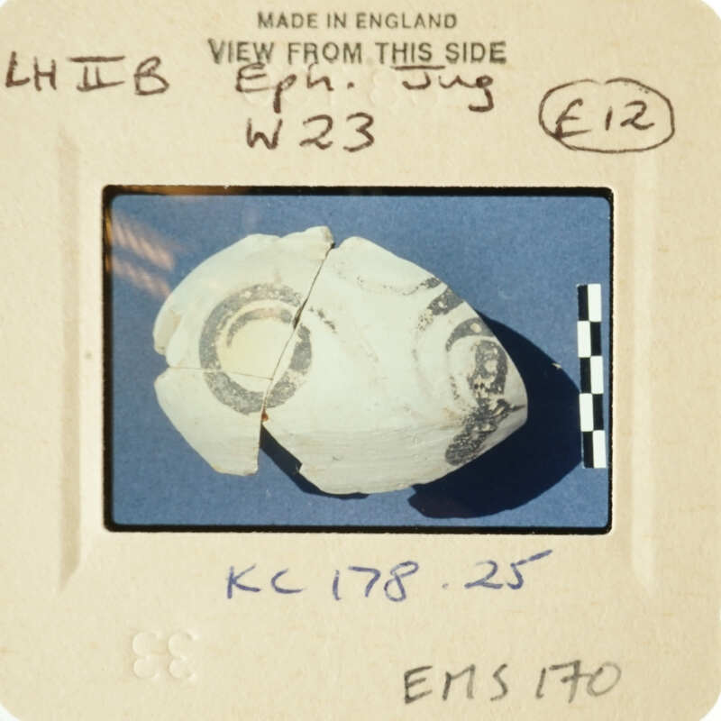 A close-up photograph of an ancient artifact, possibly pottery, with visible markings and details.
