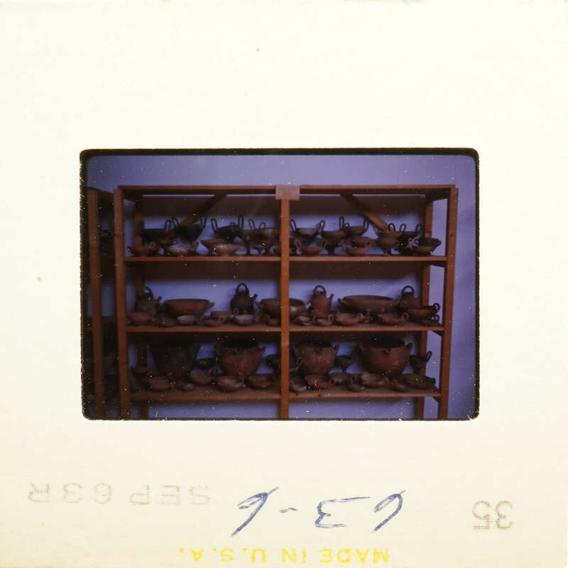 A shelf filled with various clay pots and vases.
