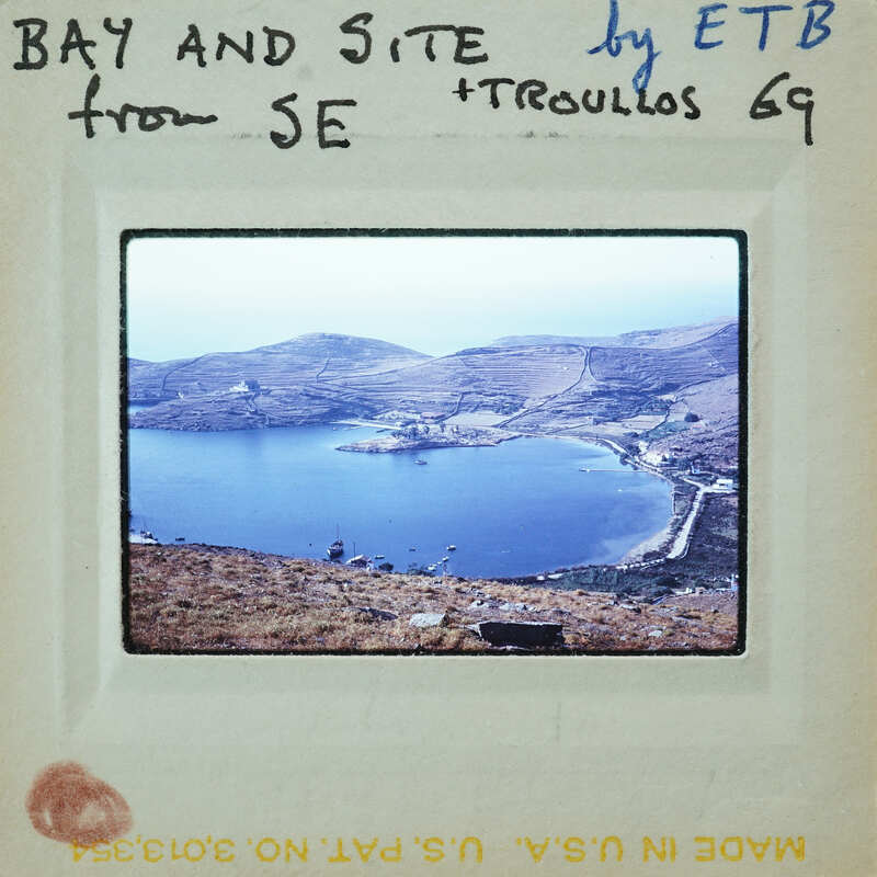 A vintage photo of a scenic bay with mountains and water, enclosed within an old-fashioned film strip frame.