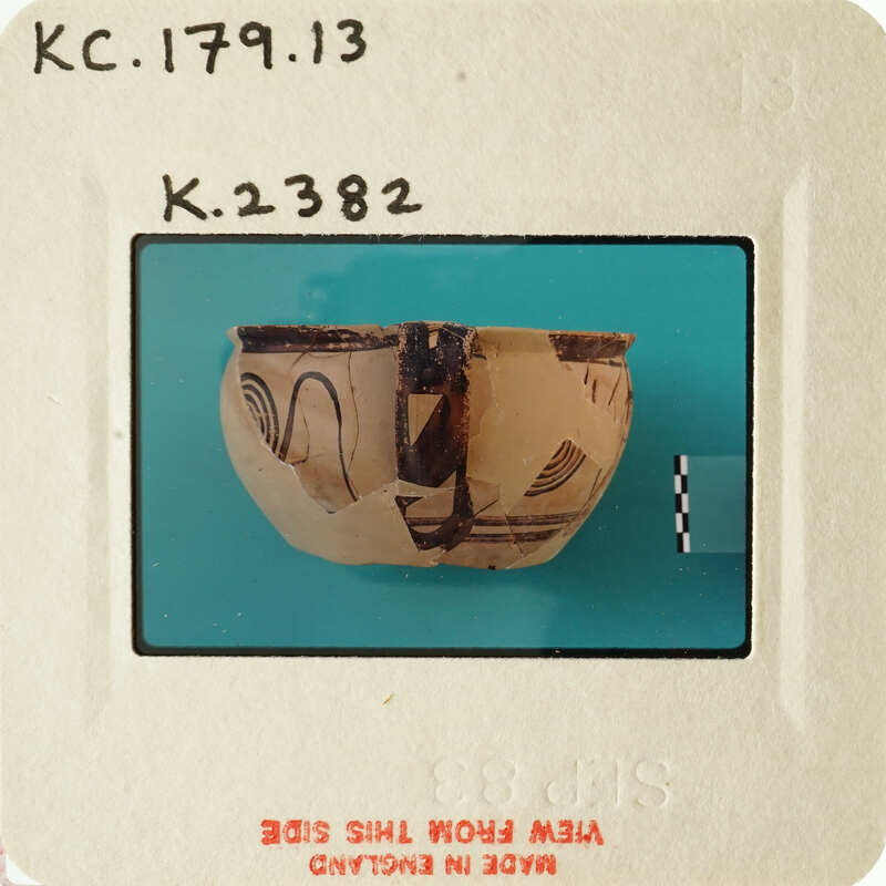 A photograph of an artifact, possibly a clay bowl with designs, on display.