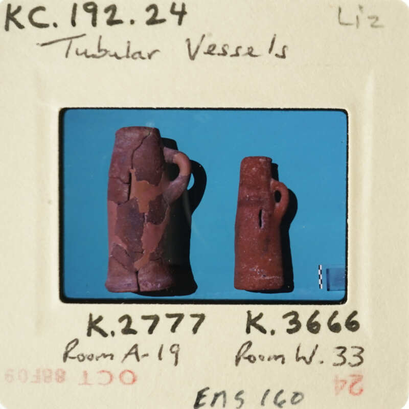 Two ancient clay vessels on display, possibly from an archaeological site.