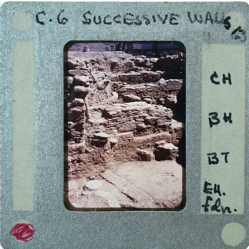 A photograph of an old brick wall with a white border and handwritten notes on the bottom.