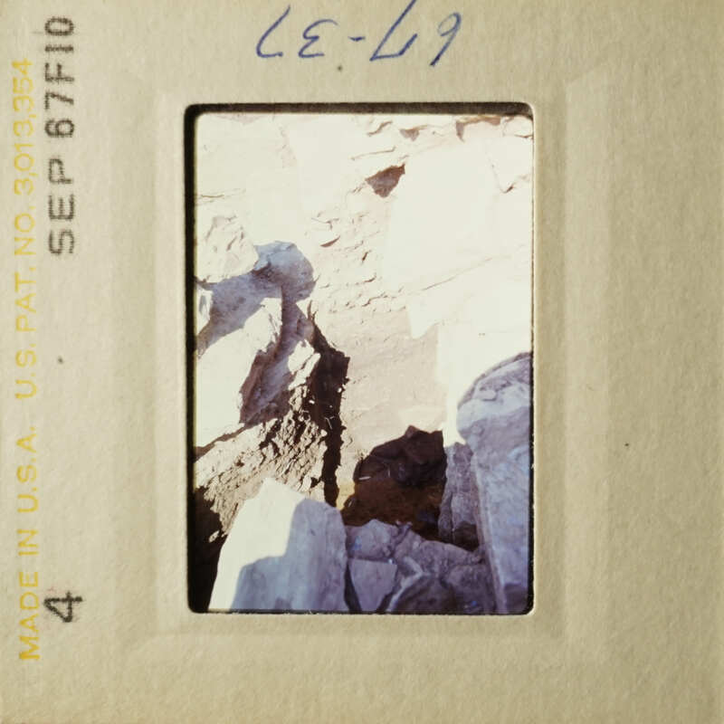 A rocky landscape with a dark crevasse and a clear sky.